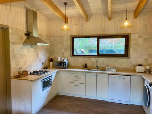 eine Küche mit weißen Schränken und einem Fenster in der Unterkunft Riberas del Futa in Valdivia