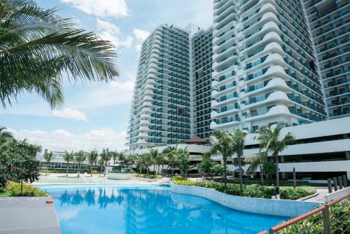 a swimming pool in front of two tall buildings at Resort Condo Unit with Stunning View - Azure North in Lagundi