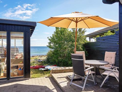 a patio with a table and an umbrella at Seaside Bliss in Sandkas - By Traum Ferienwohnungen in Allinge