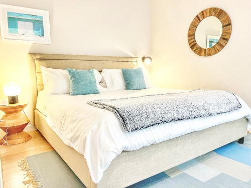 a bedroom with a large white bed with blue pillows at The Leo - One Bedroom Apartment W Private Balcony in San Diego