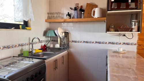 a small kitchen with a sink and a stove at Cabaña Vista Bella in Pelluhue
