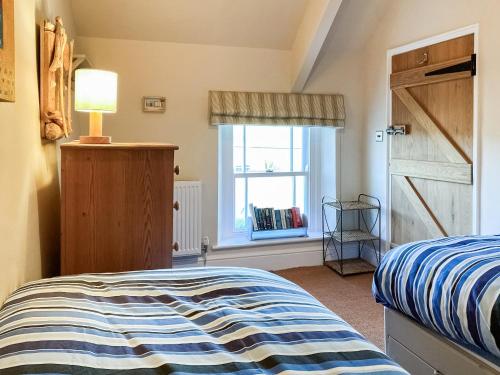a bedroom with a bed and a window at Hepzibah Cottage in Broad Haven