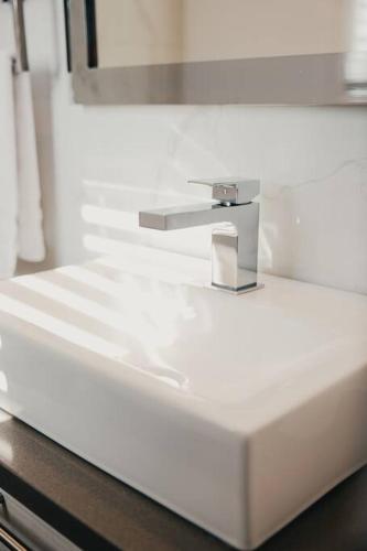 a white sink with a faucet in a bathroom at Khlozy Escape the ordinary. (Feonho) in Cornwall