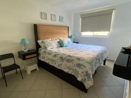 um quarto com uma cama e uma cadeira em Acapulco Diamante hermoso departamento em Acapulco