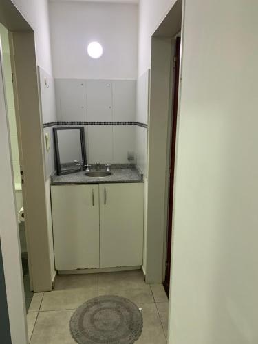 Un baño pequeño con lavabo y espejo. en VILLAGE APART, en Villa María