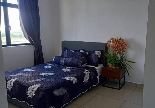- une chambre avec un lit doté d'une couette bleue et d'une fenêtre dans l'établissement Homestay In Desaru, à Bandar Penawar