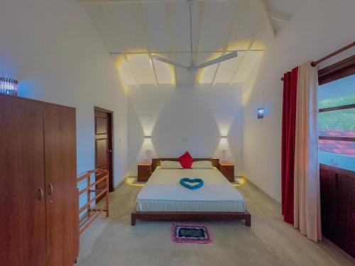 a bedroom with a bed with a blue heart on it at Sayuru Villa in Hikkaduwa