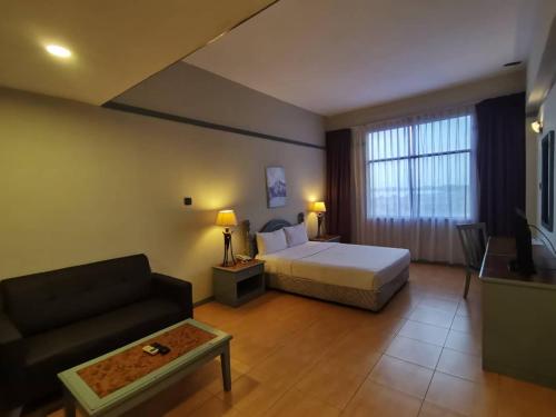 Habitación de hotel con cama y sofá en Grace Hotel Lahad Datu, en Lahad Datu