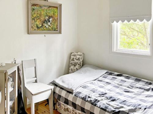 - une chambre avec un lit, une chaise et une fenêtre dans l'établissement Holiday home VÄRMDÖ VI, à Djurhamn