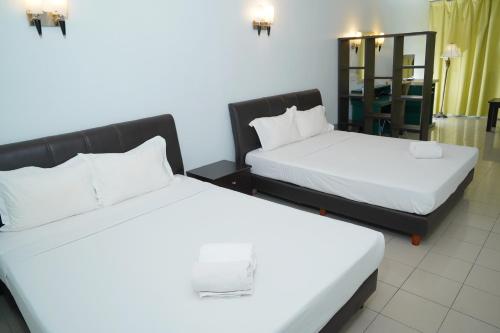 ein Hotelzimmer mit 2 Betten und einem Tisch in der Unterkunft Dowifi Hotel -Self Service Kiosk in Sungai Petani