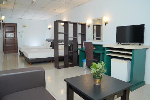ein Wohnzimmer mit einem TV, einem Sofa und einem Tisch in der Unterkunft Dowifi Hotel -Self Service Kiosk in Sungai Petani