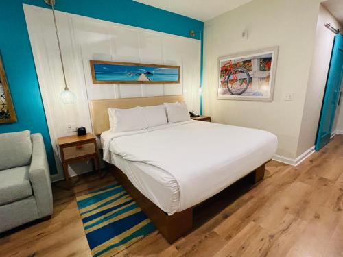 亞特蘭大的住宿－Margaritaville by Wyndham - Atlanta，卧室配有一张白色大床和一把椅子