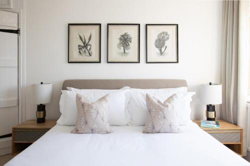 a bedroom with a white bed with three framed drawings on the wall at Number 42 in Arundel