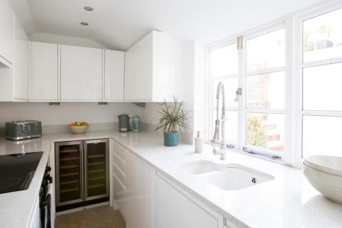 a white kitchen with a sink and a window at Number 42 in Arundel