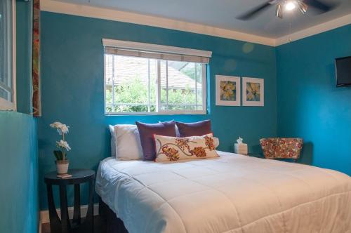 Dormitorio azul con cama y ventana en Large Groups-Seq Parks Coast Wineries Skiing-All Day Trips!, en Visalia
