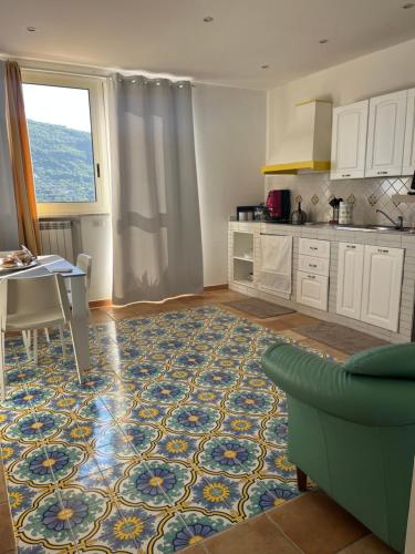 una cucina con tavolo e tappeto sul pavimento di Sirenai Apartment a Colli di Fontanelle