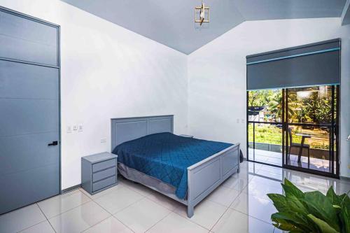 a bedroom with a bed and a large window at Hector House in Uvita