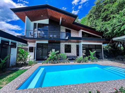uma casa com uma piscina em frente em Hector House em Uvita