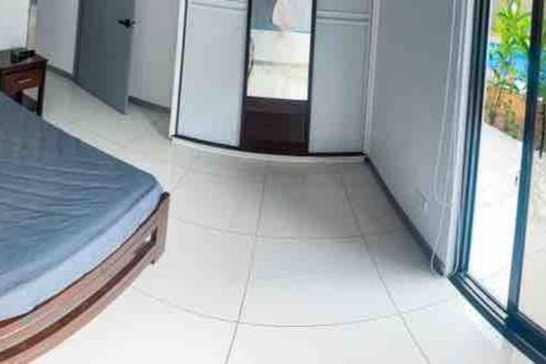 a bedroom with a bed and a white tile floor at Hector House in Uvita