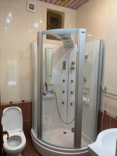 een badkamer met een douche, een toilet en een wastafel bij Коттедж на берегу оз. Севан in Sevan