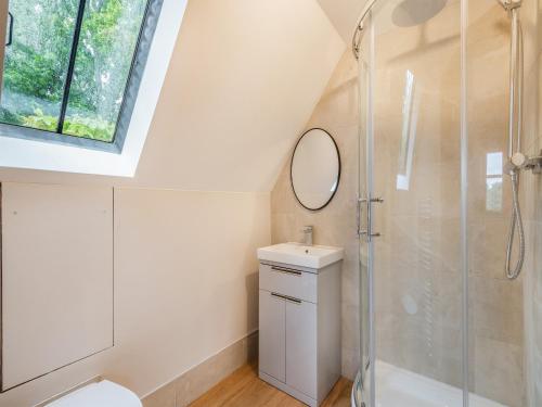 a bathroom with a shower and a sink and a mirror at Ringland Cottage in Attlebridge