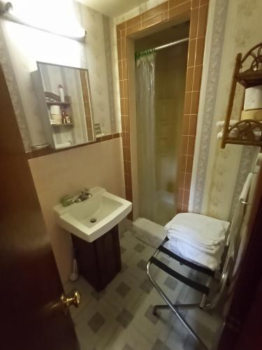 baño con lavabo, espejo y silla en Sea Breeze Inn beach rentals en Barnstable