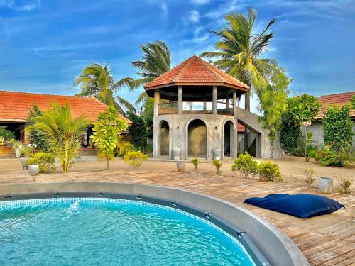 a house with a swimming pool and a gazebo at Arasi Resort in Kalpitiya