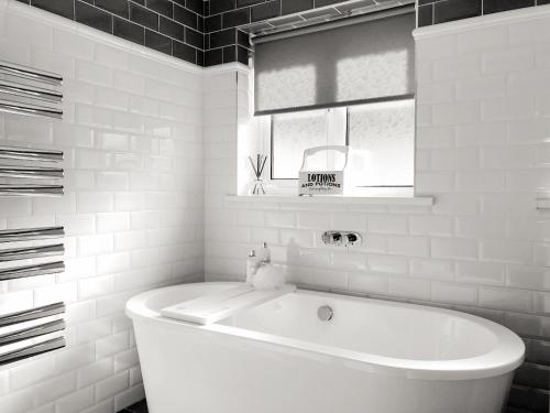 a white bath tub in a bathroom with a window at Rydal Cottage in Keswick