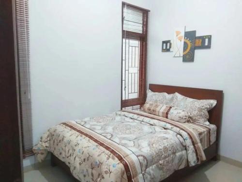 1 dormitorio con 1 cama con espejo en la pared en Walasa Ratri Indonesia Homes by MSH, en Purworejo