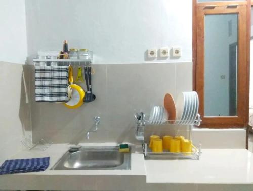 - un évier de cuisine avec un séchoir à vaisselle dans l'établissement Walasa Ratri Indonesia Homes by MSH, à Purworejo