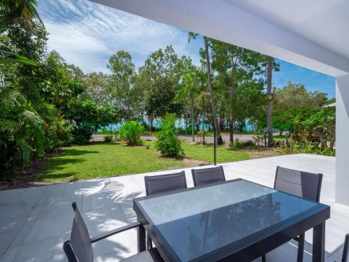 a table and chairs on a patio with a view of a park at Serene 2BR Beachfront Getaway on the Esplanade in Clifton Beach