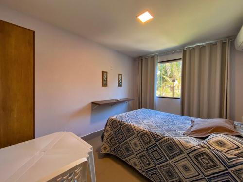 a bedroom with a bed and a window at Apt FRENTE MAR MEAIPE COMPLETO in Guarapari