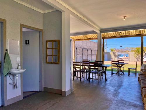 a dining room with a table and chairs and windows at Apt FRENTE MAR MEAIPE COMPLETO in Guarapari