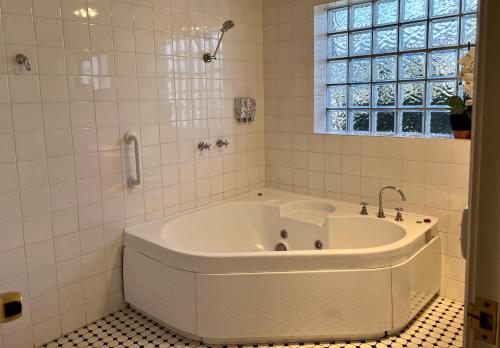 a white bath tub in a bathroom with a window at Tumut Valley Motel in Tumut