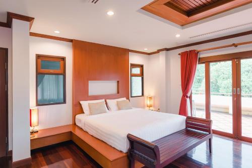 a bedroom with a large bed and a window at Ruen Thai Siray Green in Phuket