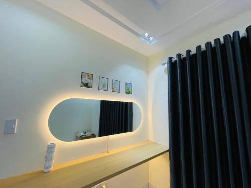 baño con espejo y cortina negra en Basic Guest House Hải Phòng, en Hai Phong