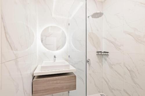 a white bathroom with a sink and a mirror at Desa Residence Kerobokan in Kerobokan