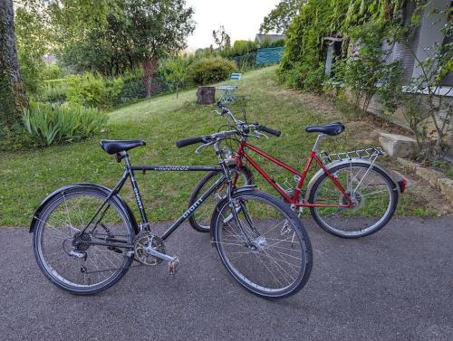 - deux vélos garés l'un à côté de l'autre dans la rue dans l'établissement Appartement indépendant 30 m² à 500m du lac, 2 vélos et parking fournis, à Sévrier
