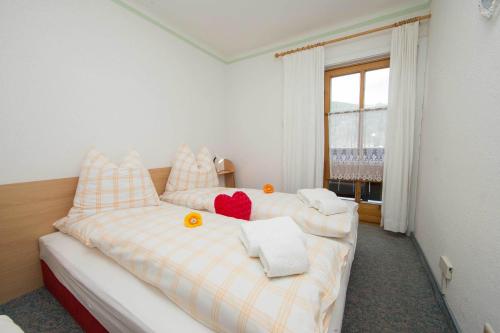 a bedroom with two beds with towels and a window at Apartments Kitzsteinhorn in Zell am See
