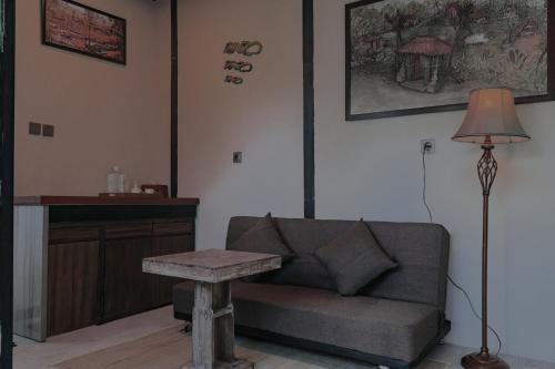 a living room with a couch and a table at Kusfarm Bali by AHM in Selemadeg