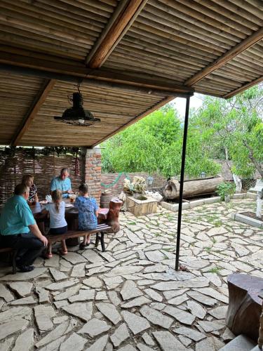 a group of people sitting on a bench in a pavilion at Safari House Tbilisi Wine & Family Hotel in Tbilisi City