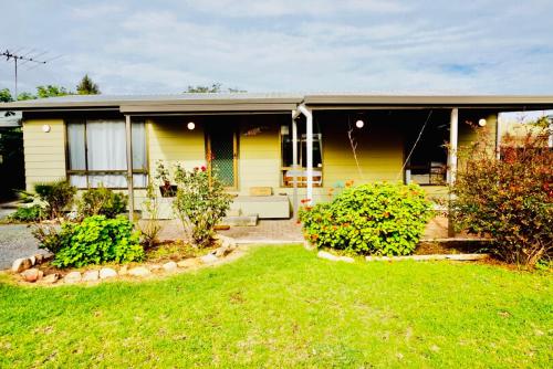 a yellow house with a garden in front of it at Decades in Port Willunga