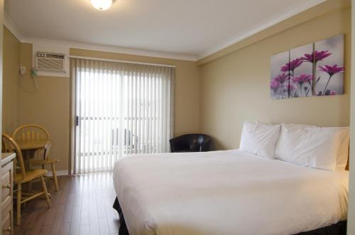 a hotel room with a bed and a window at Tiki Shores Inn & Suites in Penticton
