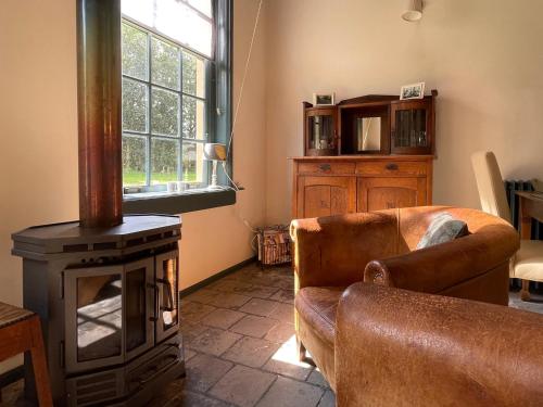 a living room with a couch and a wood stove at Logies Oud Bergveen in Veenhuizen