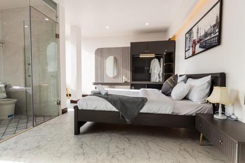 1 dormitorio con cama grande y ducha en HT House, en Da Lat