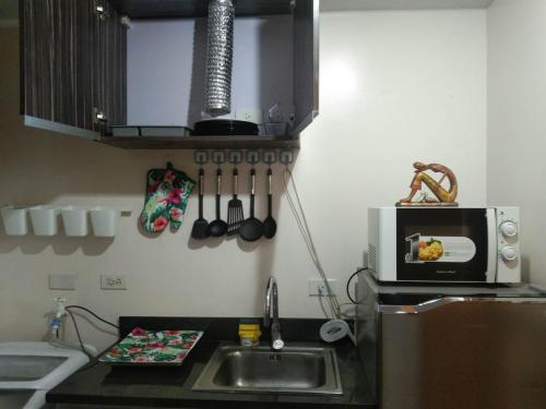 a kitchen with a sink and a microwave at Affordable place to stay near cebu city in Cebu City