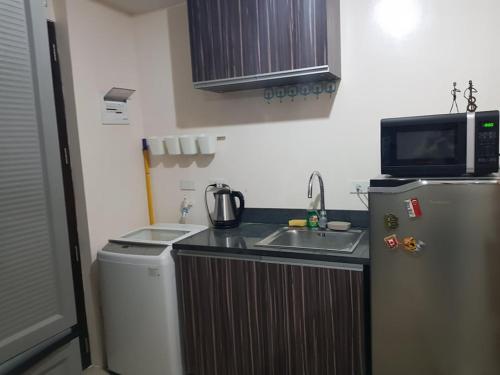 a small kitchen with a sink and a refrigerator at Affordable place to stay near cebu city in Cebu City