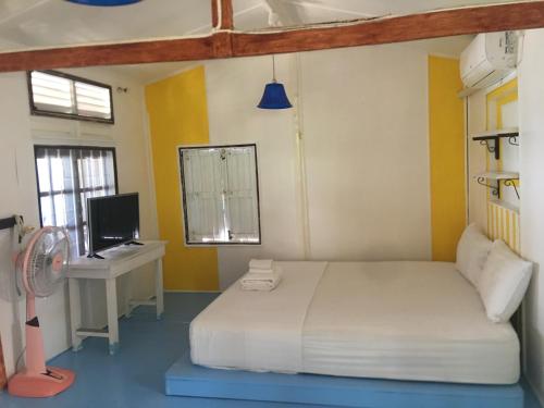 a bedroom with a bed and a desk with a computer at Bangpo Village in Ban Bang Po