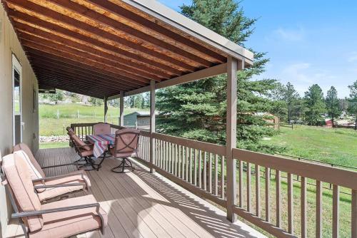 a porch with a wooden deck with chairs and awning at Papa’s Place on Willow Creek in Custer