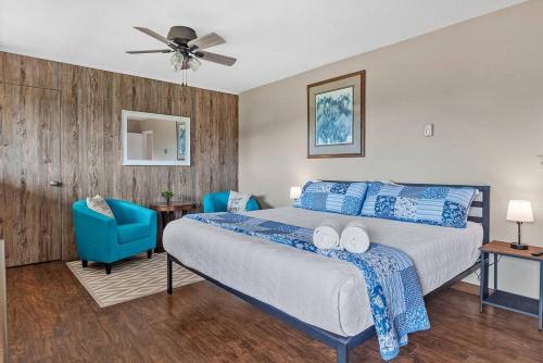 ein Schlafzimmer mit einem Bett und zwei blauen Stühlen in der Unterkunft Papa’s Place on Willow Creek in Custer